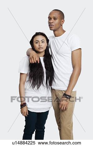 Portrait of serious young couple in casuals standing against white background View Large Photo Image Stock Photography - Portrait of serious young couple in casuals standing against white background. Fotosearch