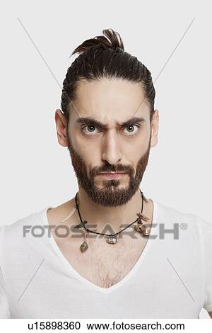 Portrait of serious young man in white t-shirt over white background View Large Photo Image Stock Image - Portrait of serious young man in white t-shirt over white background. Fotosearch