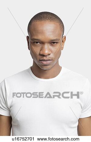 Portrait of serious young man in white t-shirt against white background View Large Photo Image Stock Image - Portrait of serious young man in white t-shirt against white background. Fotosearch