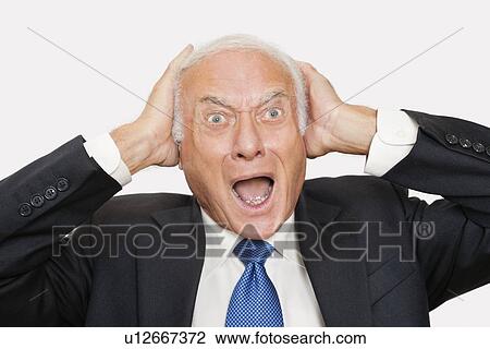 Stock Image - Portrait of shocked elderly businessman against white background. Fotosearch