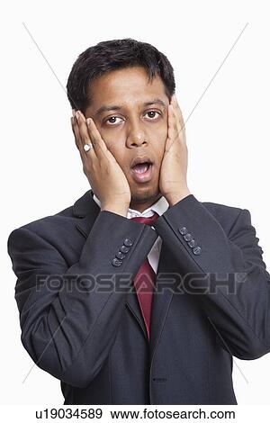 Portrait of shocked young businessman against white background View Large Photo Image Stock Photo - Portrait of shocked young businessman against white background. Fotosearch