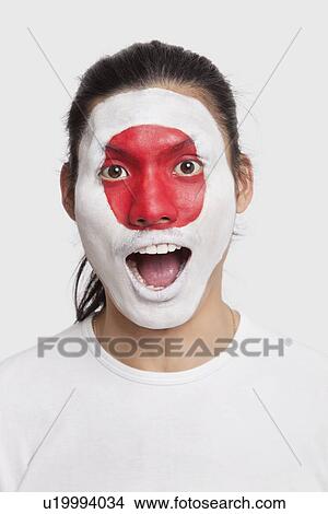 Portrait of surprised young mixed race man with Japanese flag painted on face against white background View Large Photo Image Picture - Portrait of surprised young mixed race man with Japanese flag painted on face against white background. Fotosearch