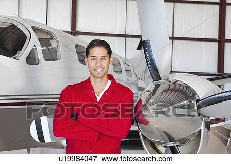 Portrait of young aeronautic engineer standing in front of airplane View Large Photo Image Stock Photo - Portrait of young aeronautic engineer standing in front of airplane. Fotosearch