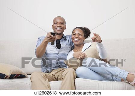 Portrait of young African American couple watching TV at home View Large Photo Image Stock Photo - Portrait of young African American couple watching TV at home. Fotosearch