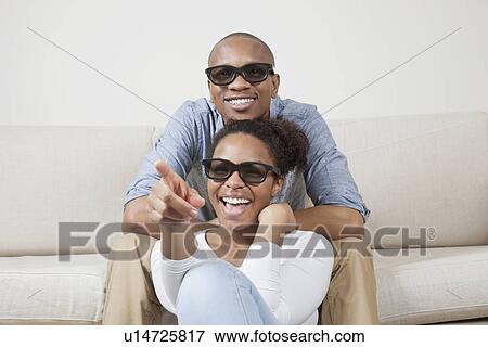 Portrait of young African American couple wearing 3D glasses and watching TV View Large Photo Image Stock Photo - Portrait of young African American couple wearing 3D glasses and watching TV. Fotosearch