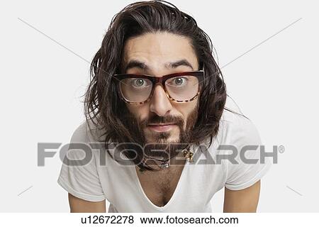 Portrait of young Asian man with eyeglasses staring against white background View Large Photo Image Stock Photo - Portrait of young Asian man with eyeglasses staring against white background. Fotosearch