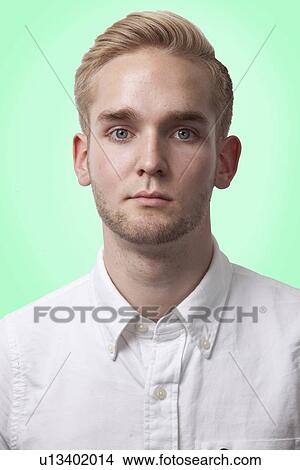 Picture - Portrait of young Caucasian man against green background. Fotosearch