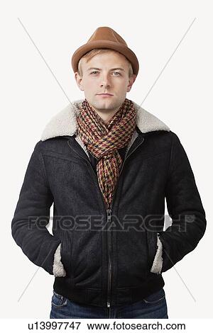 Portrait of young Caucasian man in warm clothing standing against white background View Large Photo Image Stock Photo - Portrait of young Caucasian man in warm clothing standing against white background. Fotosearch