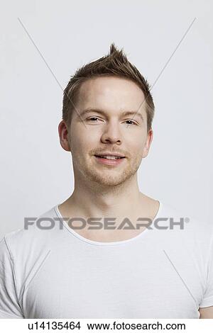 Picture - Portrait of young Caucasian man with spiked hair against white background. Fotosearch