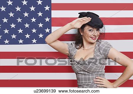 Portrait of young Caucasian woman with veiled hat saluting against American flag View Large Photo Image Stock Photo - Portrait of young Caucasian woman with veiled hat saluting against American flag. Fotosearch