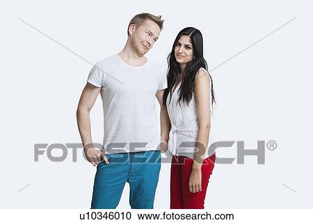 Stock Image - Portrait of young couple in casuals over white background. Fotosearch