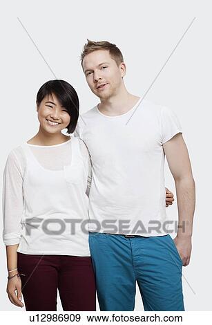 Portrait of young couple in casuals smiling over white background View Large Photo Image Stock Photo - Portrait of young couple in casuals smiling over white background. Fotosearch