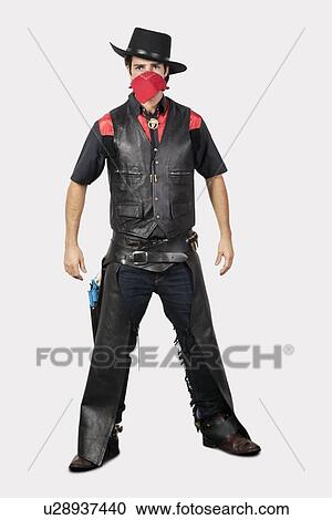 Portrait of young cowboy standing against gray background View Large Photo Image Stock Image - Portrait of young cowboy standing against gray background. Fotosearch