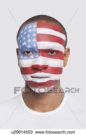 Portrait of young Hispanic man with North American flag painted on face against white background View Large Photo Image Stock Image - Portrait of young Hispanic man with North American flag painted on face against white background. Fotosearch
