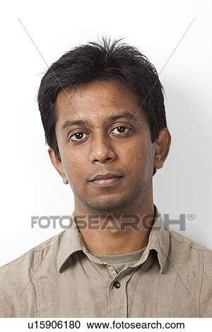 Stock Image - Portrait of young Indian man against white background. Fotosearch