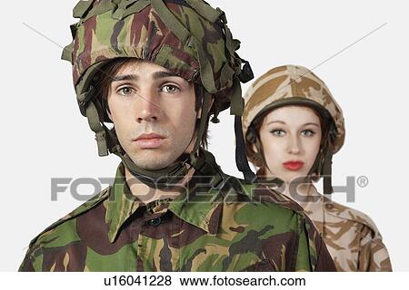 Stock Photo - Portrait of young man and woman in military clothes against gray background. Fotosearch