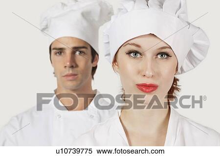 Portrait of young man and woman in chef's uniform against gray background View Large Photo Image Stock Photography - Portrait of young man and woman in chef's uniform against gray background. Fotosearch