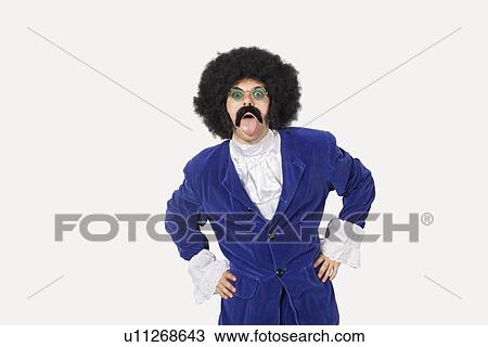 Portrait of young man in blue coat sticking out tongue against gray background View Large Photo Image Stock Image - Portrait of young man in blue coat sticking out tongue against gray background. Fotosearch