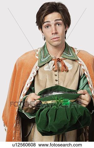 Portrait of young man in old-fashioned costume begging against gray background View Large Photo Image Stock Photo - Portrait of young man in old-fashioned costume begging against gray background. Fotosearch