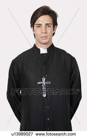 Portrait of young man in priest costume against gray background View Large Photo Image Stock Photo - Portrait of young man in priest costume against gray background. Fotosearch