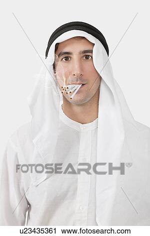Portrait of young man smoking bunch of cigarettes over white background View Large Photo Image Stock Image - Portrait of young man smoking bunch of cigarettes over white background. Fotosearch