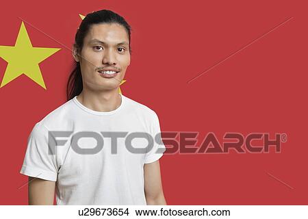 Portrait of young mixed race man standing against Chinese flag View Large Photo Image Picture - Portrait of young mixed race man standing against Chinese flag. Fotosearch