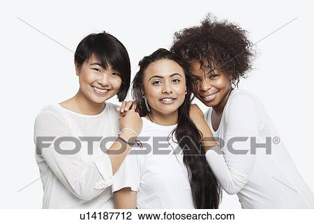 Portrait of young multi-ethnic female friends smiling over white background View Large Photo Image Stock Image - Portrait of young multi-ethnic female friends smiling over white background. Fotosearch