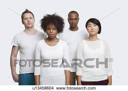 Picture - Portrait of young multi-ethnic friends in casuals standing together over white background. Fotosearch
