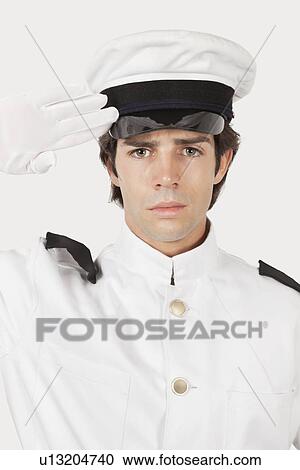Portrait of young navy officer saluting against gray background View Large Photo Image Stock Image - Portrait of young navy officer saluting against gray background. Fotosearch