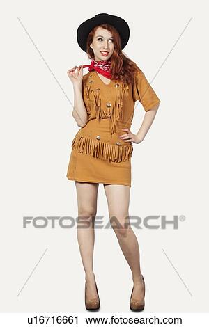 Portrait of young woman dressed as cowgirl against gray background View Large Photo Image Stock Image - Portrait of young woman dressed as cowgirl against gray background. Fotosearch