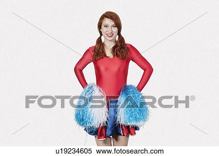 Portrait of young woman in cheer leader costume standing against gray background View Large Photo Image Stock Photography - Portrait of young woman in cheer leader costume standing against gray background. Fotosearch