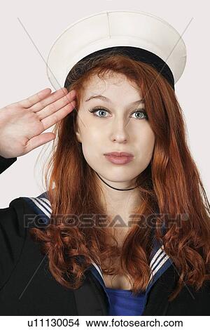 Portrait of young woman in sailor's uniform saluting against gray background View Large Photo Image Picture - Portrait of young woman in sailor's uniform saluting against gray background. Fotosearch
