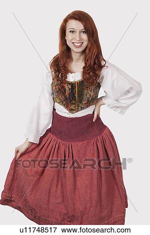Portrait of young woman in old-fashioned costume standing against gray background View Large Photo Image Stock Photo - Portrait of young woman in old-fashioned costume standing against gray background. Fotosearch