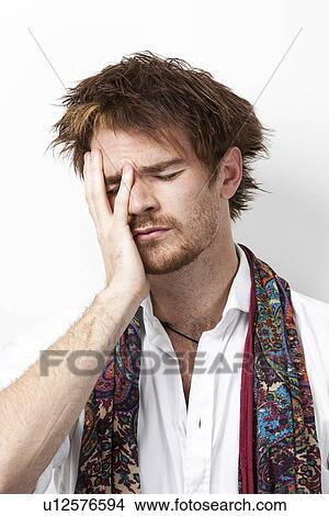 Sad young man with hand on face against white background View Large Photo Image Picture - Sad young man with hand on face against white background. Fotosearch