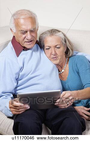 Senior couple using digital tablet at home View Large Photo Image Stock Photograph - Senior couple using digital tablet at home. Fotosearch