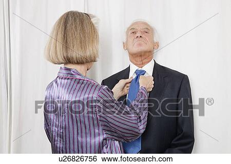 Senior woman adjusting husband's necktie View Large Photo Image Stock Photograph - Senior woman adjusting husband's necktie. Fotosearch