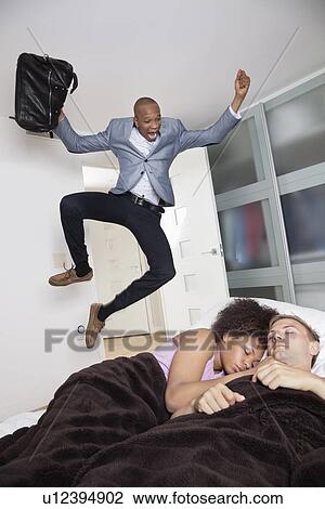 Shocked businessman looking at couple sleeping in bed View Large Photo Image Stock Image - Shocked businessman looking at couple sleeping in bed. Fotosearch