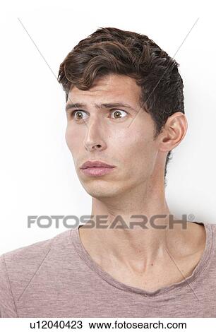 Shocked young man looking away against white background View Large Photo Image Stock Image - Shocked young man looking away against white background. Fotosearch