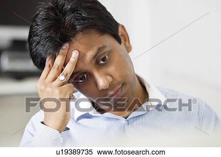 Tensed young businessman with hand on head at office View Large Photo Image Stock Photography - Tensed young businessman with hand on head at office. Fotosearch