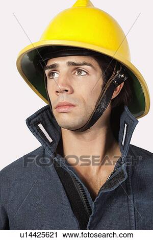 Thoughtful fireman looking away against gray background View Large Photo Image Stock Image - Thoughtful fireman looking away against gray background. Fotosearch
