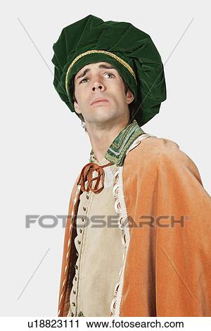 Stock Image - Thoughtful young man in old-fashioned costume looking away against gray background. Fotosearch