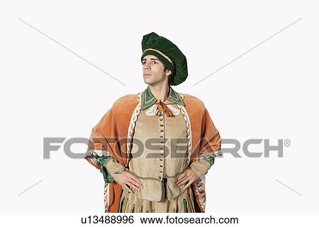 Thoughtful young man in old-fashioned costume with hands on hips against gray background View Large Photo Image Stock Photograph - Thoughtful young man in old-fashioned costume with hands on hips against gray background. Fotosearch
