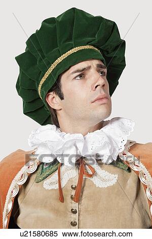 Thoughtful young man in old-fashioned costume looking away against gray background View Large Photo Image Stock Photography - Thoughtful young man in old-fashioned costume looking away against gray background. Fotosearch