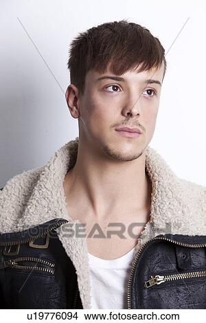 Picture - Thoughtful young man looking away against white background. Fotosearch