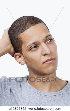 Thoughtful young mixed race man against white background View Large Photo Image Stock Image - Thoughtful young mixed race man against white background. Fotosearch