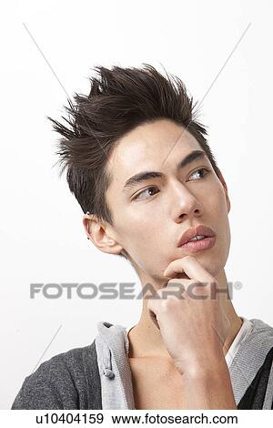 Stock Photo - Thoughtful young mixed race man looking away against white background. Fotosearch