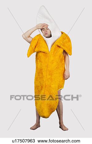 Tired man in banana costume against gray background View Large Photo Image Stock Image - Tired man in banana costume against gray background. Fotosearch