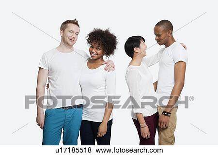 Two young couples in casuals standing together over white background View Large Photo Image Stock Photo - Two young couples in casuals standing together over white background. Fotosearch