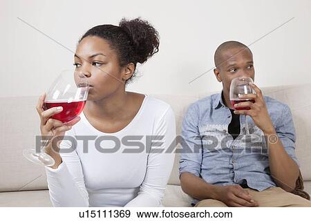 Young African American couple drinking red wine at home View Large Photo Image Stock Photo - Young African American couple drinking red wine at home. Fotosearch