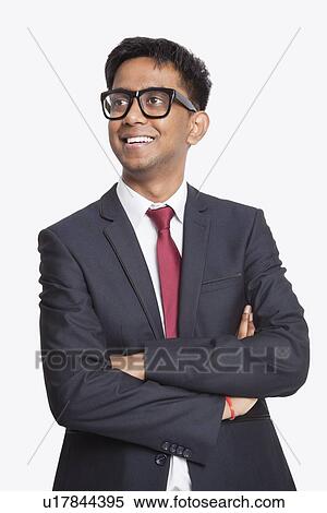 Young Asian businessman with arms crossed day dreaming against white background View Large Photo Image Stock Photography - Young Asian businessman with arms crossed day dreaming against white background. Fotosearch